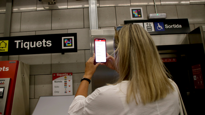 Mar Masdeu fent servir el NaviLens al vestíbul de l'estació de metro de Tetuan (L2) | Albert Hernàndez (ACN)